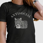 Woman wearing a black T-shirt with a grumpy cat illustration and the word ‘Antisocial.’ Funny cat lover and rescue volunteer shirt. Cat With Ear Tip makes it perfect for TNR Feral Cat Trap Advocates.