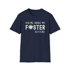 Navy soft t-shirt with text that reads ‘Ask Me About My Foster Kittens’ and a retro styled rainbow paw-print graphic in the word Foster