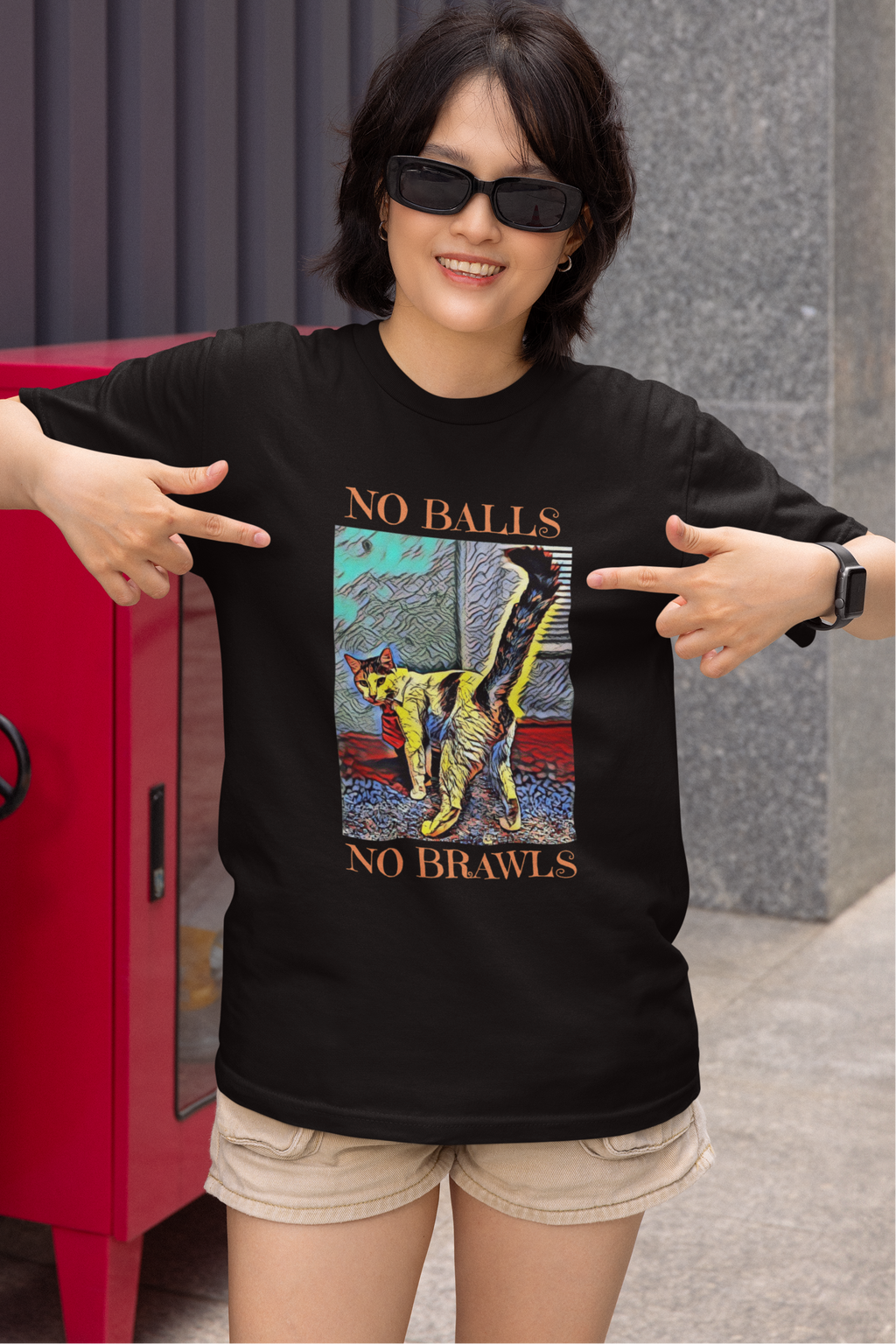 TNR Cat Advocate Shirt in Black Colorful Artistic Design of a sassy cat with tail held high.  Woman is smiling and pointing proudly to the design on her short sleeved crewneck shirt.