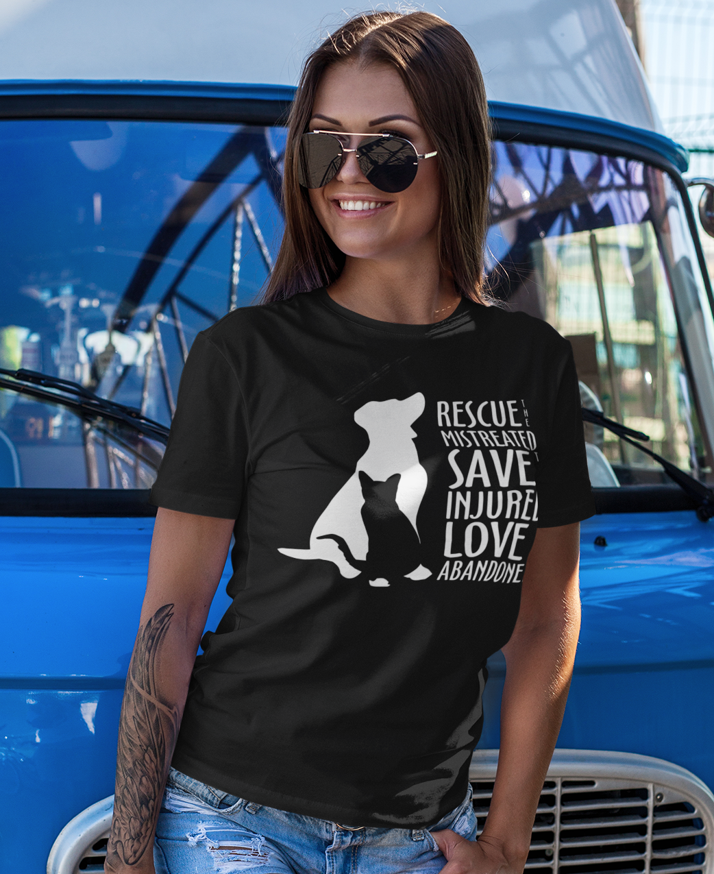 woman wearing a Black shirt with white silhouette of a cat and dog beside the words “Rescue the Mistreated, Save the Injured, Love the Abandoned.” Animal rescue awareness design supporting adopt don’t shop, TNR, and shelter pet advocacy.